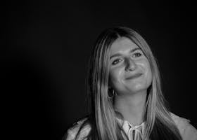 A graceful black and white portrait of a smiling young woman with long blonde hair.